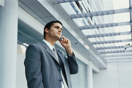 simsearch:632-03083042,k - Businessman standing outside office building using cell phone Stock Photo - Premium Royalty-Free, Code: 632-03083731