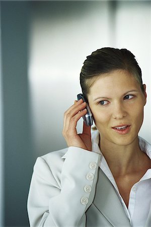 simsearch:632-03083042,k - Businesswoman using cell phone, glancing sideways Stock Photo - Premium Royalty-Free, Code: 632-03083755