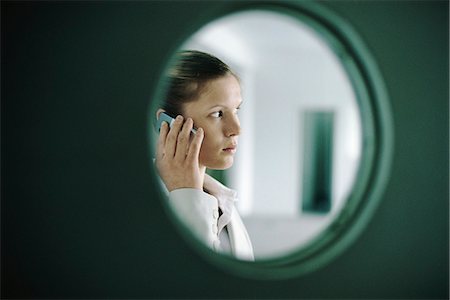 simsearch:632-03083042,k - Woman using cell phone, viewed through window Stock Photo - Premium Royalty-Free, Code: 632-03083752