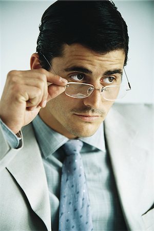 simsearch:614-06813654,k - Businessman looking away, lowering glasses, portrait Foto de stock - Sin royalties Premium, Código: 632-03083774