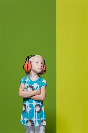 schmollen (beleidigt sein) - Kleines Mädchen mit Armen gefaltet, das Tragen von Schutzkleidung Kopfhörer, trotzig Wegsehen Stockbilder - Premium RF Lizenzfrei, Bildnummer: 632-03193355