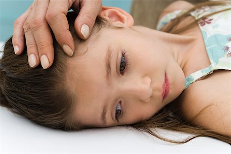 simsearch:632-03424324,k - Little girl lying on back, parent stroking her forehead, cropped Stock Photo - Premium Royalty-Free, Code: 632-03193475