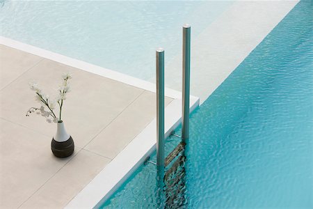 Flowers in vase at edge of pool near ladder Stock Photo - Premium Royalty-Free, Code: 632-03193622