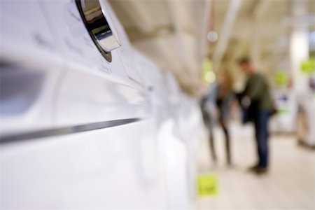 Control knob on appliance, shoppers in background Stock Photo - Premium Royalty-Free, Code: 632-03193746