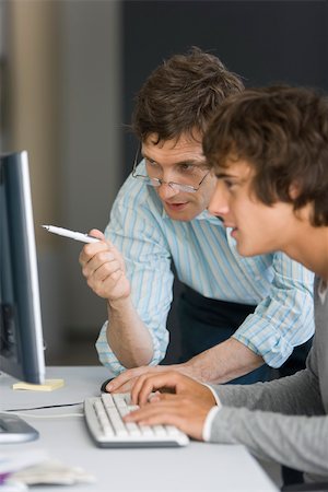Teacher assisting student with computer assignment Stock Photo - Premium Royalty-Free, Code: 632-03403303
