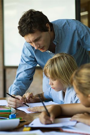 Teacher helping young students with classwork Stock Photo - Premium Royalty-Free, Code: 632-03424199
