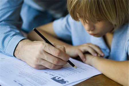 Male junior high student watches as teacher corrects assignment, close-up Stock Photo - Premium Royalty-Free, Code: 632-03424207