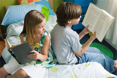 simsearch:632-03424261,k - Siblings reading together, girl glancing over shoulder at brother's book Stock Photo - Premium Royalty-Free, Code: 632-03424245