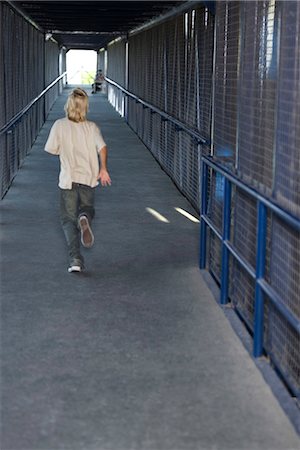 Boy running down corridor, rear view Stock Photo - Premium Royalty-Free, Code: 632-03424531