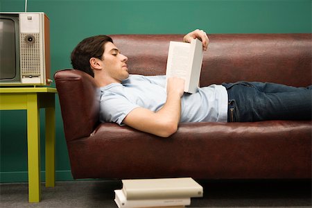 simsearch:632-03083700,k - Young man relaxing on sofa with book Stock Photo - Premium Royalty-Free, Code: 632-03424637