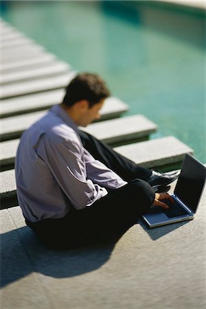 simsearch:632-03083042,k - Businessman sitting on ground beside pool, using laptop computer Stock Photo - Premium Royalty-Free, Code: 632-03424687