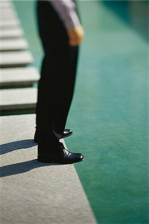 Businessman standing at edge of pool, low section Stock Photo - Premium Royalty-Free, Code: 632-03424688