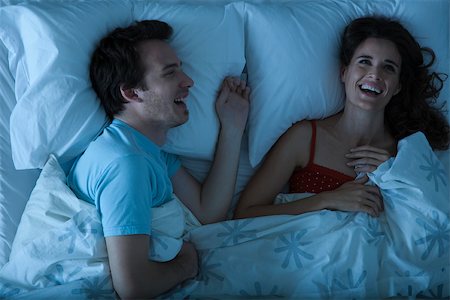 sleeping in - Couple lying together in bed laughing Stock Photo - Premium Royalty-Free, Code: 632-03500828