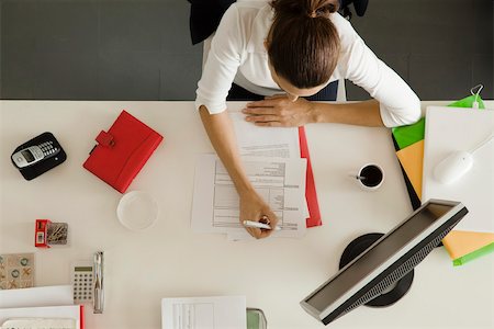 Businesswoman at desk busy with paperwork Stock Photo - Premium Royalty-Free, Code: 632-03500822