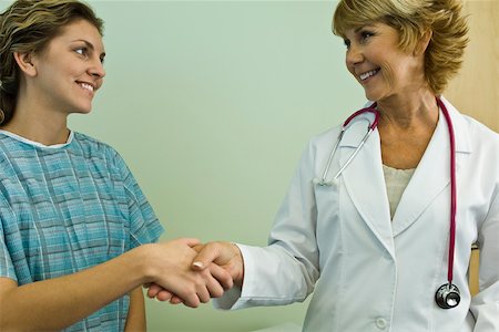 Doctor shaking hands with patient, both smiling Stock Photo - Premium Royalty-Free, Code: 632-03516741