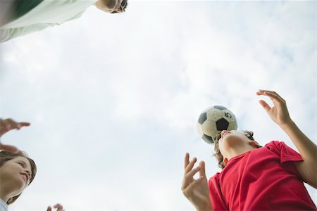 father playing football - Father and sons playing soccer, low angle view Stock Photo - Premium Royalty-Free, Code: 632-03517006