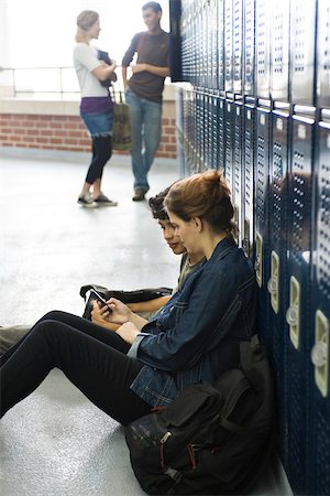 High school friends looking at cell phone together Stock Photo - Premium Royalty-Free, Code: 632-03630220
