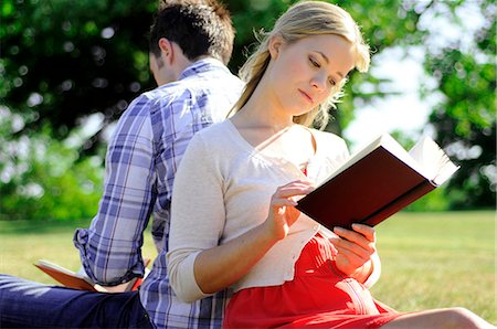 Couple sitting back to back reading in park Stock Photo - Premium Royalty-Free, Code: 632-03651766