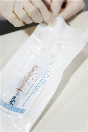 sterilization - Healthcare worker opening sterile package containing medical syringe Stock Photo - Premium Royalty-Free, Code: 632-03651956