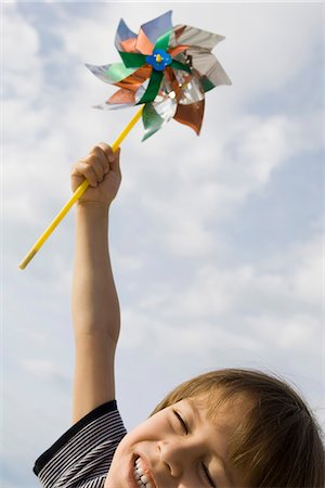 energía eólica - Boy holding pinwheel triumphantly in air Foto de stock - Sin royalties Premium, Código: 632-03652255