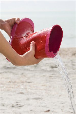 empty shoes - Pouring water out of rubber boot Stock Photo - Premium Royalty-Free, Code: 632-03652327