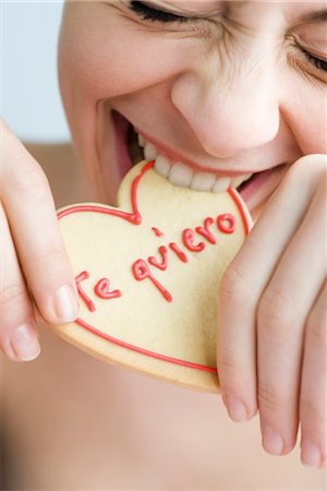spanish ethnicity (female) - Biting into heart-shaped cookie Stock Photo - Premium Royalty-Free, Code: 632-03754217