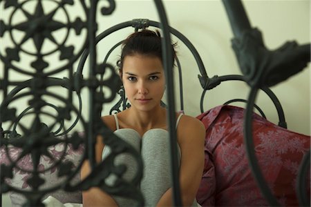 decorative iron - Young woman sitting on bed, portrait Stock Photo - Premium Royalty-Free, Code: 632-03754325