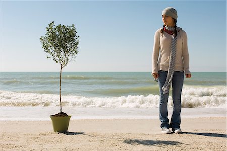 preteen girls at beach - Preteen girl on beach standing near potted tree set near water's edge Stock Photo - Premium Royalty-Free, Code: 632-03754490