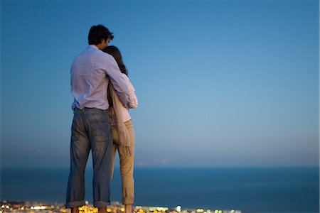 proximity - Couple standing on edge of infinity pool at dusk, looking at sea Stock Photo - Premium Royalty-Free, Code: 632-03779443