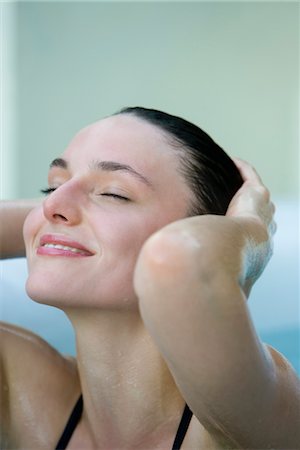 simsearch:632-05991893,k - Woman smoothing back wet hair, eyes closed Stock Photo - Premium Royalty-Free, Code: 632-03779620
