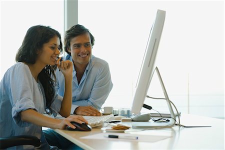 Couple looking at desktop computer together, both smiling Stock Photo - Premium Royalty-Free, Code: 632-03779709