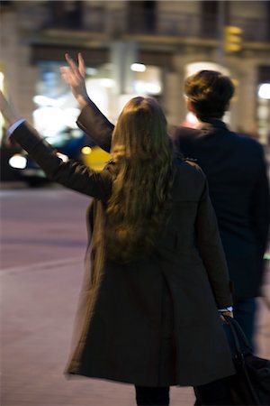 Couple hailing taxi at night, rear view Stock Photo - Premium Royalty-Free, Code: 632-03779702