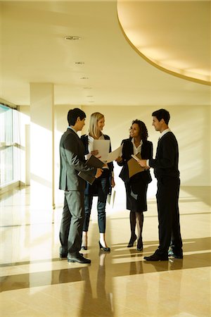 Business executives standing together discussing documents Stock Photo - Premium Royalty-Free, Code: 632-03779807