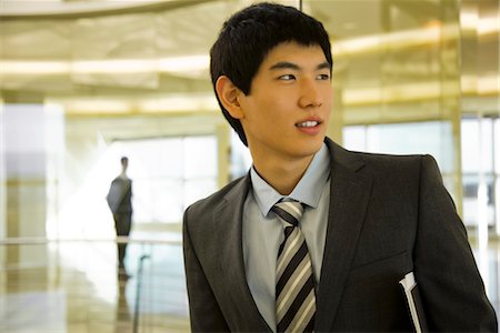 Young businessman looking away in thought, portrait Stock Photo - Premium Royalty-Free, Code: 632-03779825