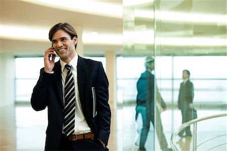 simsearch:632-05400935,k - Businessman talking on cell phone in lobby Stock Photo - Premium Royalty-Free, Code: 632-03779832