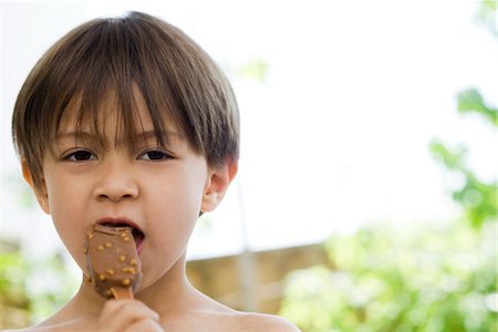 enjoy ice cream - Little boy eating ice cream bar, portrait Stock Photo - Premium Royalty-Free, Code: 632-03847868