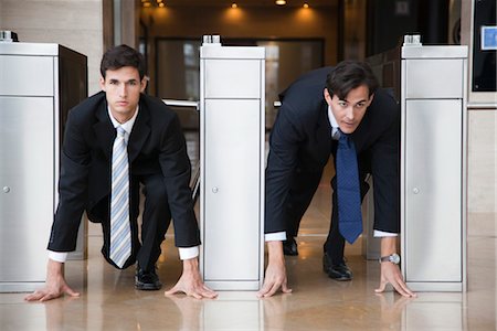 start line - Businessmen crouching in starting position in lobby turnstiles Foto de stock - Sin royalties Premium, Código: 632-03848101