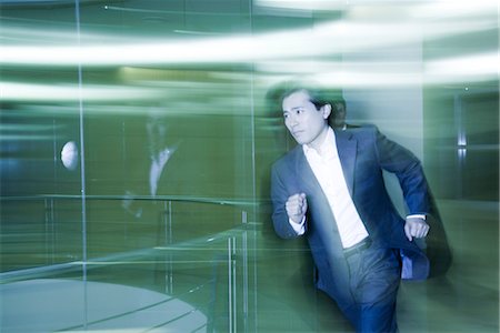 productivity - Businessman running in lobby Stock Photo - Premium Royalty-Free, Code: 632-03848102