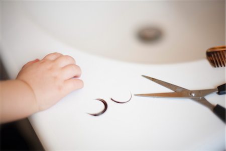 strand - Child's hand resting on sink near scissors and locks of hair Stock Photo - Premium Royalty-Free, Code: 632-03848295
