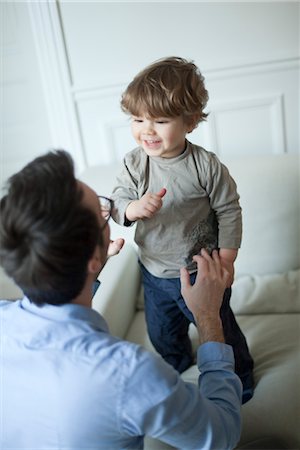 simsearch:632-03848361,k - Toddler boy standing on couch, smiling at father Stock Photo - Premium Royalty-Free, Code: 632-03848437