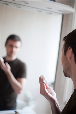 Man looking at self in mirror, shaving cream in hand Stock Photo - Premium Royalty-Free, Code: 632-03897772