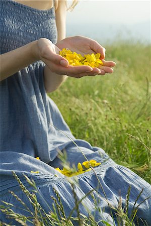 pune - Young woman kneeling in meadow, holding flower petals in hands, cropped Foto de stock - Sin royalties Premium, Código: 633-05401371