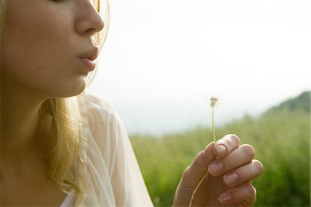summer light - Young woman blowing dandelion seedhead Foto de stock - Sin royalties Premium, Código: 633-05401648