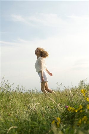 Young woman running through meadow Stock Photo - Premium Royalty-Free, Code: 633-05401681
