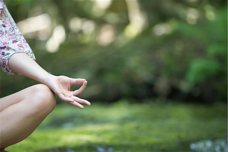 Young woman sitting in lotus position outdoors, cropped Stock Photo - Premium Royalty-Free, Code: 633-05401840
