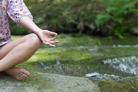 Young woman sitting in lotus position outdoors, cropped Stock Photo - Premium Royalty-Free, Code: 633-05402134