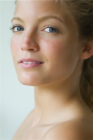 freckles - Young woman looking over shoulder at camera, portrait Stock Photo - Premium Royalty-Free, Code: 633-05402189