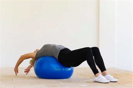 Woman lying on fitness ball stretching Stock Photo - Premium Royalty-Free, Code: 633-06322485