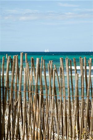 Tranquil beach scene with bamboo fence in foreground Foto de stock - Sin royalties Premium, Código: 633-06406594