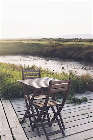 Wooden table and chairs on deck in tranquil scene Stock Photo - Premium Royalty-Free, Code: 633-08150944